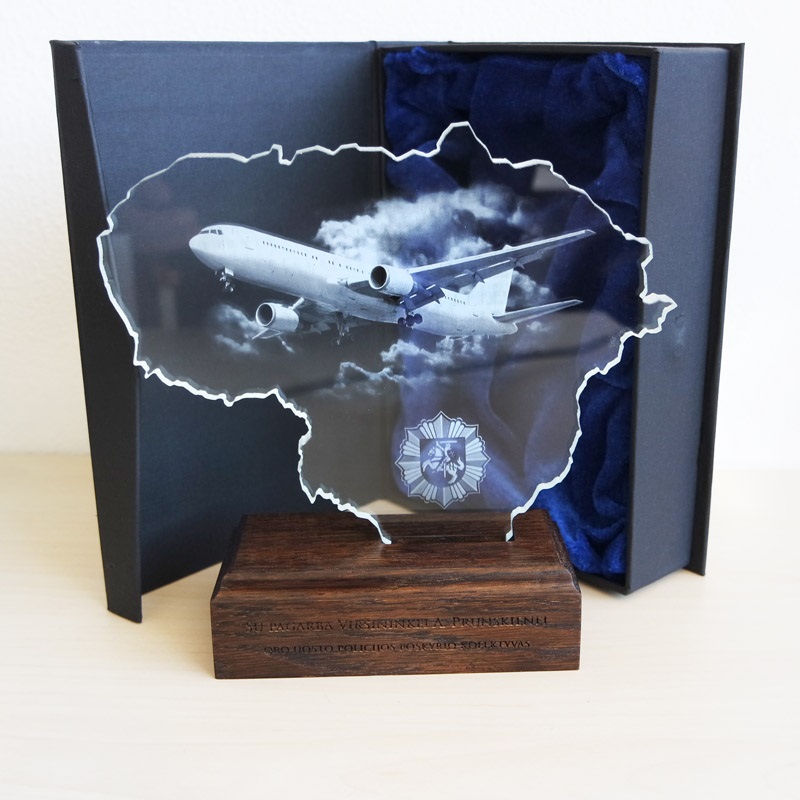 Individualus graviruotas stiklo apdovanojimas su Lietuvos žemėlapiu ir mediniu stovu, simbolizuojantis orlaivių skrydžius ir aviacijos pasiekimus